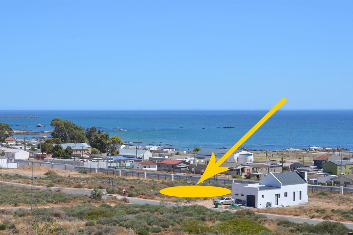 An elevated aerial view of a vacant residential plot located in a coastal neighborhood, featuring clear ocean views and proximity to existing infrastructure.