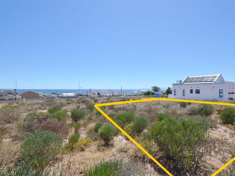 Vacant residential land plot with coastal views, featuring natural vegetation and proximity to existing residential infrastructure.