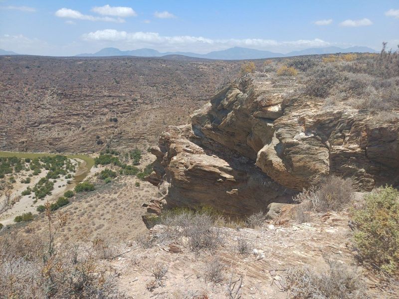 A scenic view overlooking a rugged river valley and rocky cliff landscape, showcasing the natural terrain of the farm property.