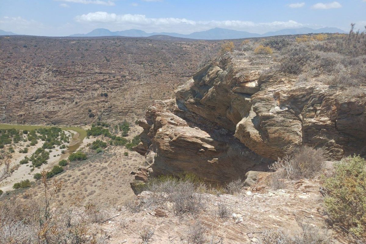A scenic view overlooking a rugged river valley and rocky cliff landscape, showcasing the natural terrain of the farm property.