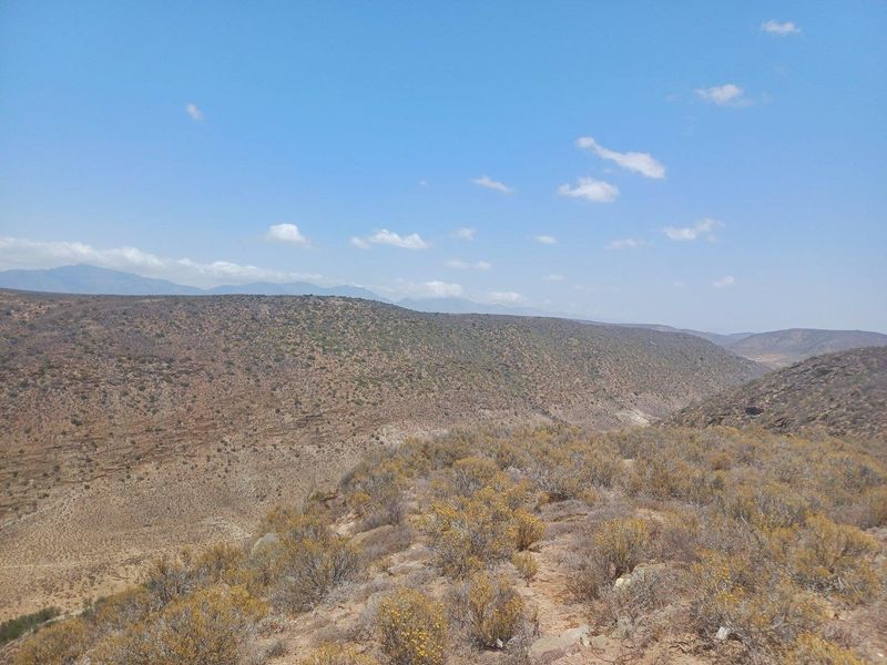 Expansive panoramic landscape view overlooking the rugged terrain and hills of the farm property.