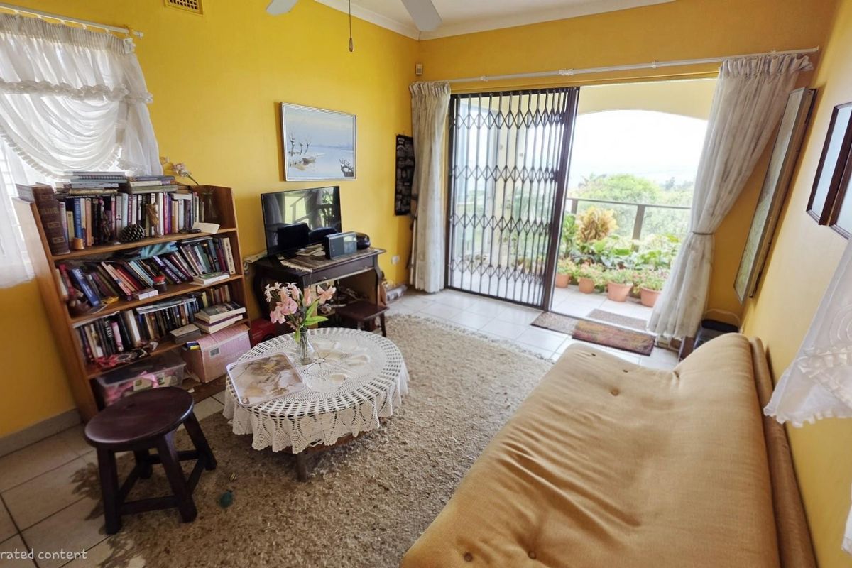 A living room featuring tiled flooring, ceiling fan, and sliding security gate access to an outdoor balcony area.