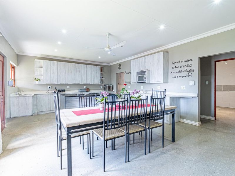Spacious open-plan kitchen and dining area featuring modern light-wood cabinetry, polished concrete floors, and recessed lighting.