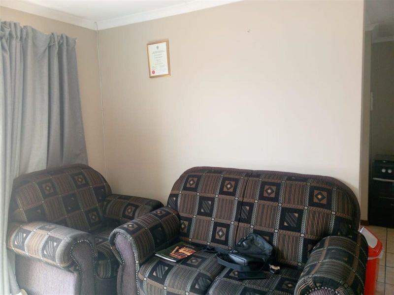 A view of the living area featuring tiled flooring and neutral wall finishes.