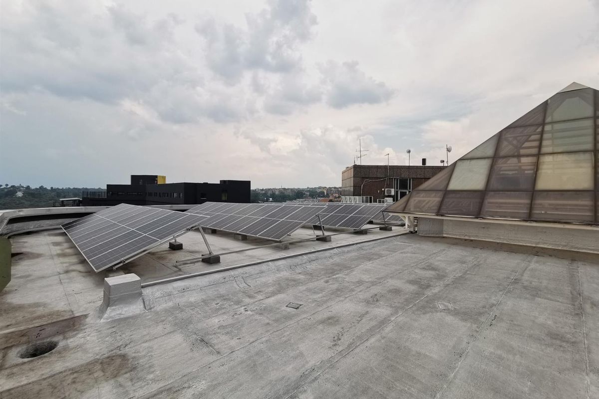Rooftop area featuring a solar panel array installation and a large pyramid-style skylight structure.