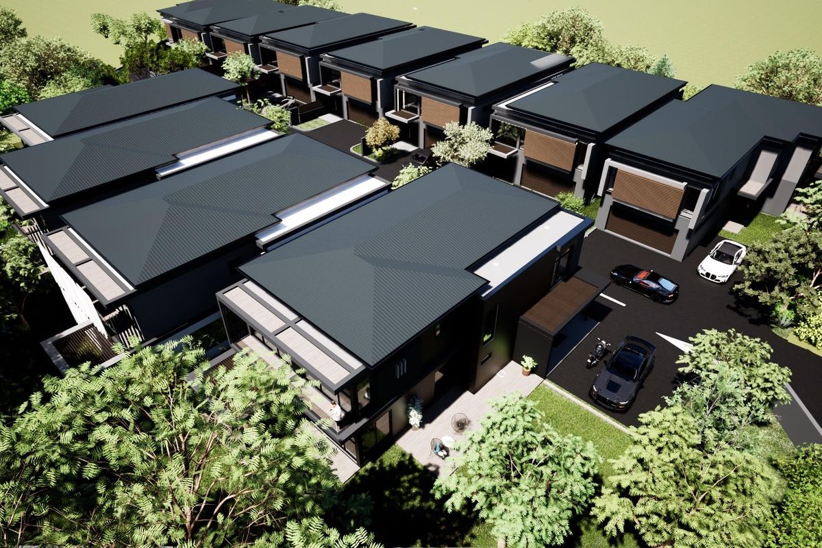 An aerial view of a modern residential development featuring multiple townhouses with dark metal roofing and integrated parking areas.
