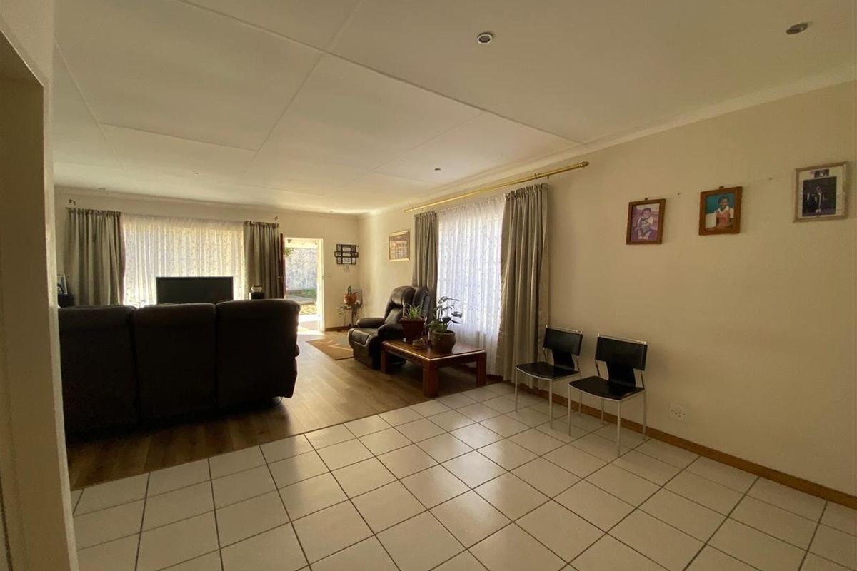 Spacious living area featuring a combination of tiled and laminate flooring, providing a versatile layout for comfortable family living.