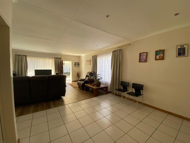 Spacious living area featuring a combination of tiled and laminate flooring, providing a versatile layout for comfortable family living.