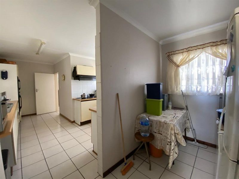 A functional kitchen area featuring tiled flooring, built-in cabinetry, and integrated cooking appliances, offering a practical layout for daily meal preparation.