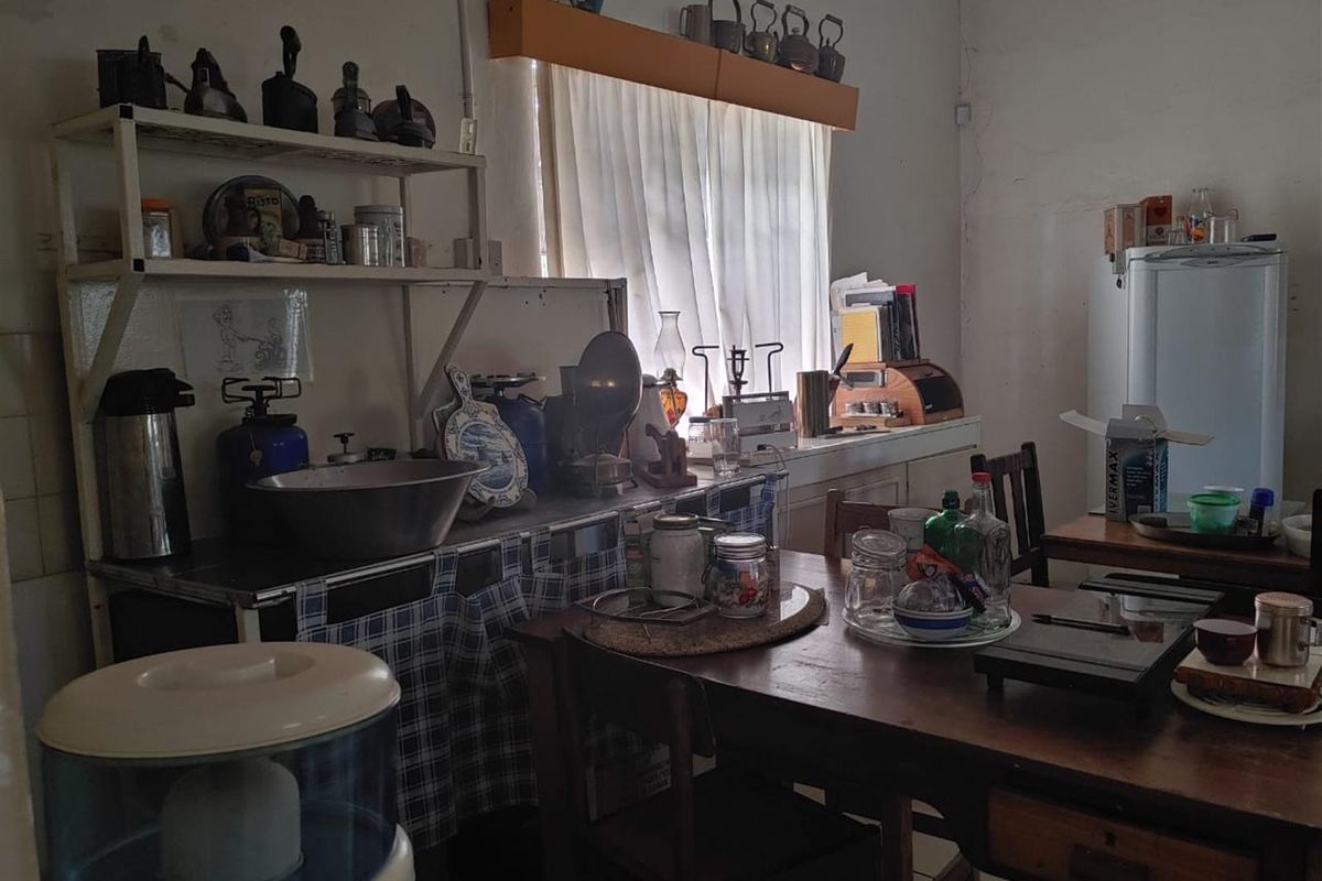 A dated kitchen area featuring built-in shelving and tiled flooring, currently showing significant signs of wear and requiring cosmetic updates.