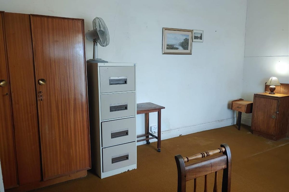 A bedroom featuring carpeted flooring and visible wall cracks, requiring cosmetic updates to improve the overall condition and aesthetic appeal.