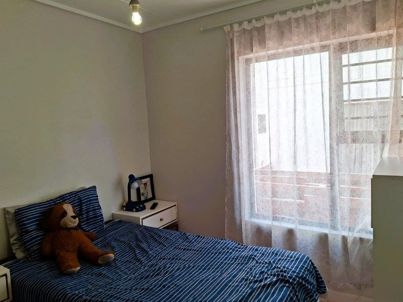 A standard bedroom featuring a window with a curtain rail, providing natural light and a functional space for rest.