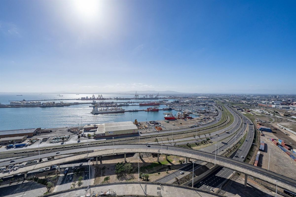 An elevated aerial view showcasing the coastal harbour, industrial port facilities, and surrounding highway infrastructure.