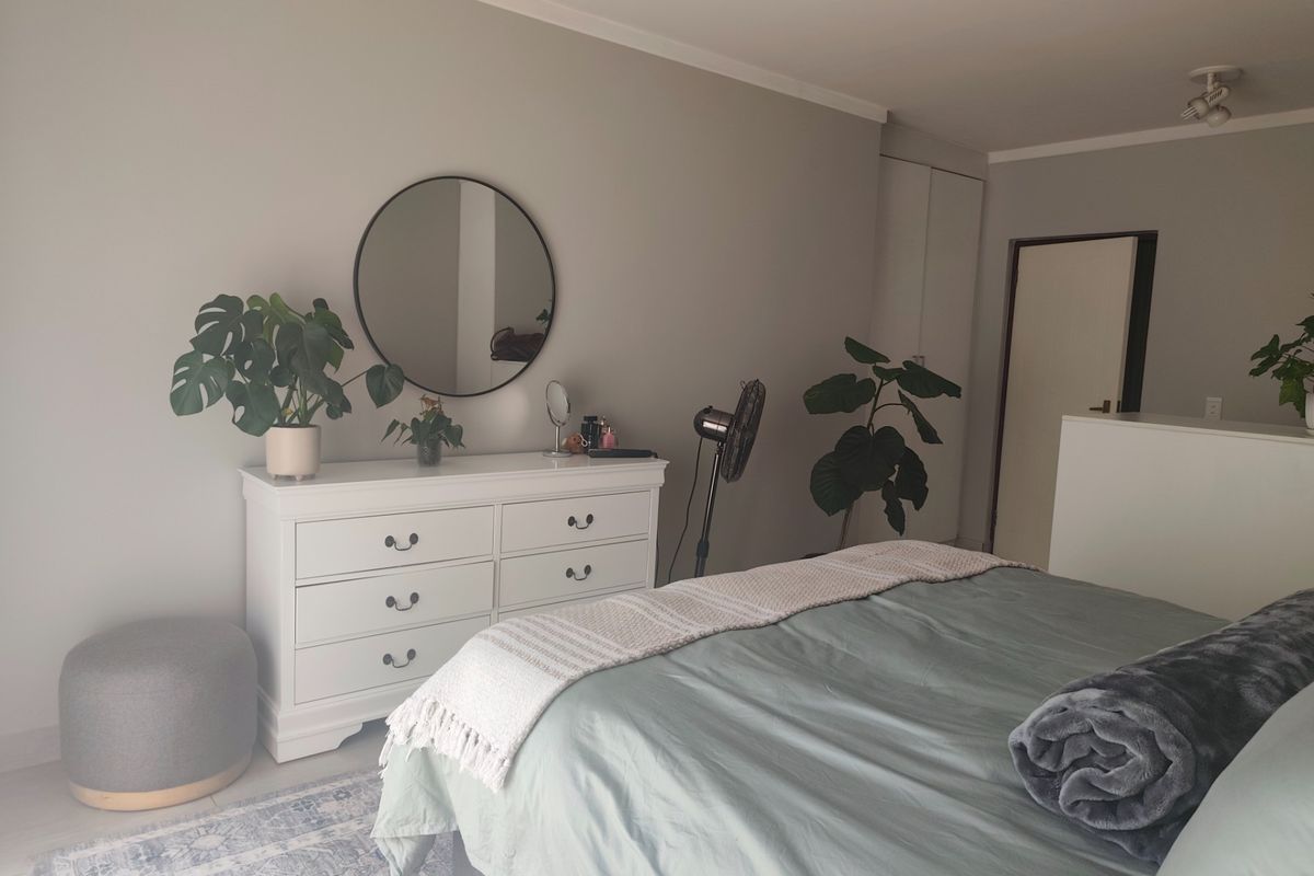 A well-maintained bedroom featuring neutral wall tones, built-in storage cupboards, and a functional layout with ample space.