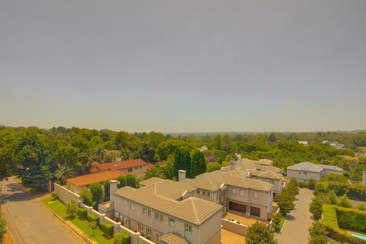 Aerial view of the apartment complex showing the building structure, tiled roofing, and surrounding landscaped grounds.
