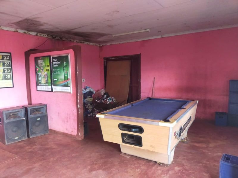 A bar area featuring a partition wall and visible signs of ceiling water damage and wall surface deterioration.