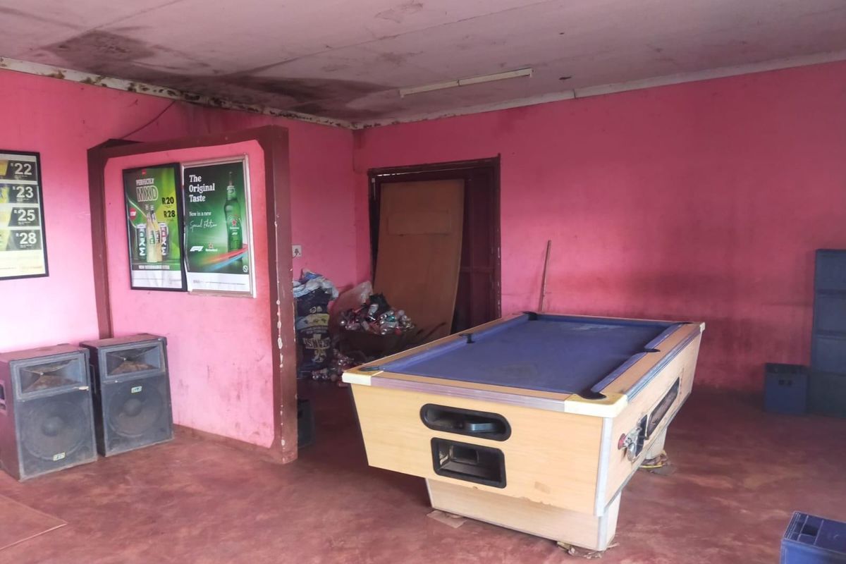 A bar area featuring a partition wall and visible signs of ceiling water damage and wall surface deterioration.