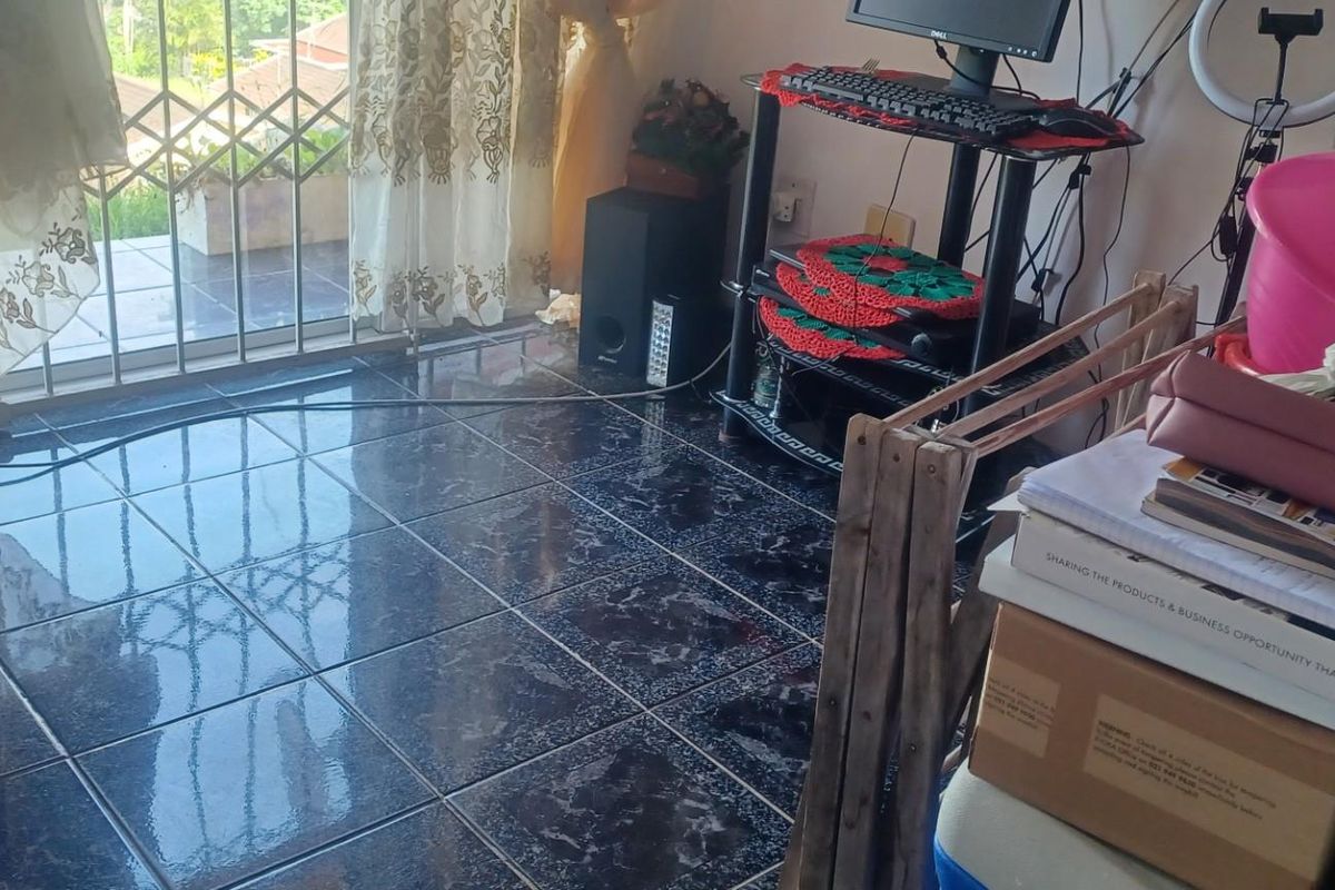 A living area featuring dark marble-effect floor tiles and a sliding glass door providing access to an outdoor balcony space.