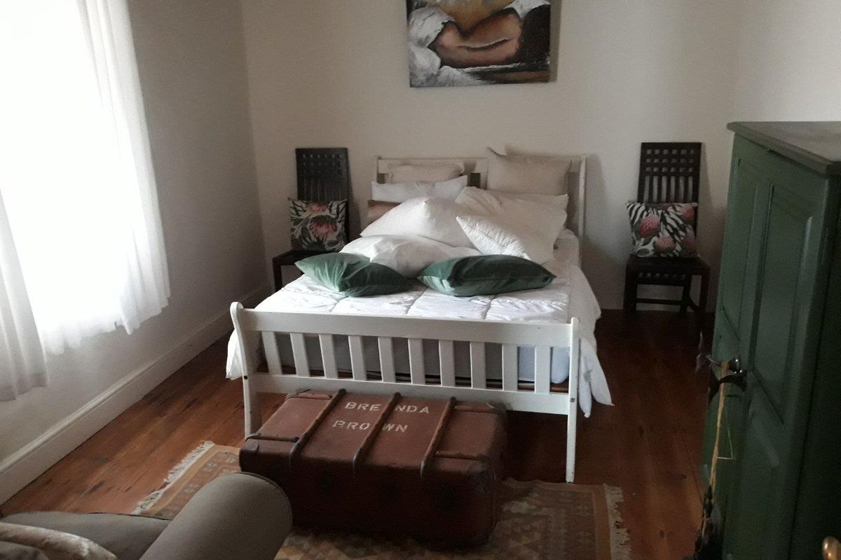 A cozy bedroom featuring polished timber flooring and neutral wall finishes, providing a comfortable and inviting sleeping space.