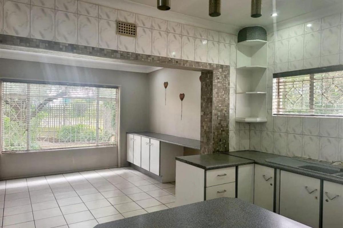 A functional kitchen featuring tiled surfaces, built-in cabinetry, and ample counter space, offering a neutral foundation for modern updates.