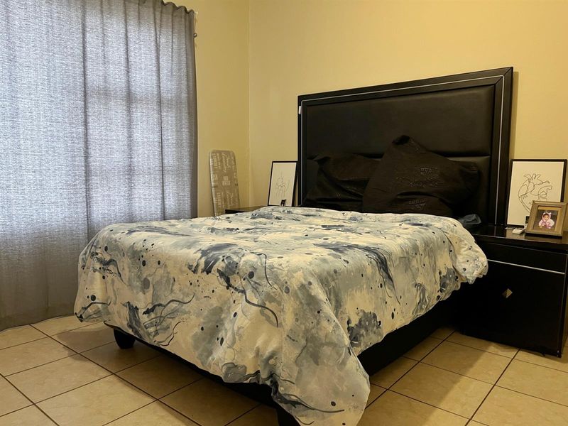 A bedroom featuring ceramic tile flooring and neutral wall finishes, providing a functional space for rest.
