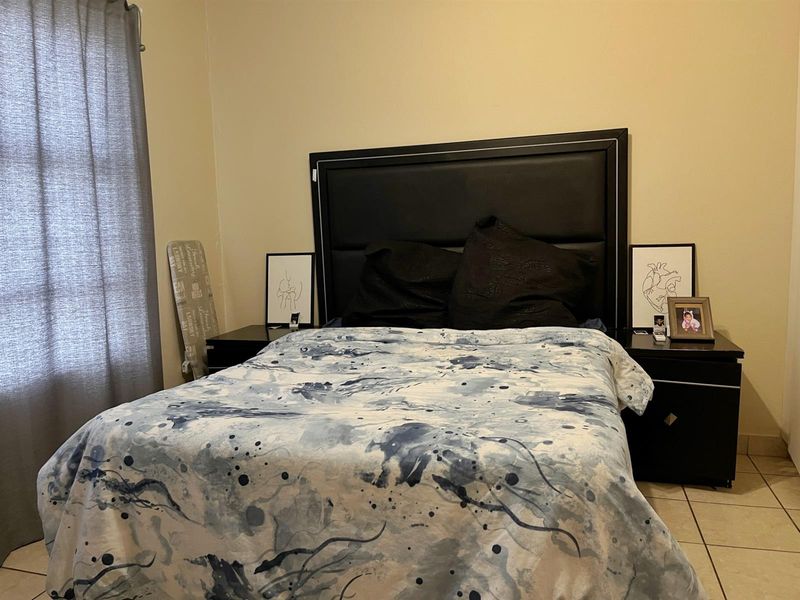 A bedroom featuring tiled flooring and neutral wall finishes, providing a functional space for rest.
