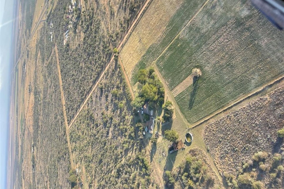 Aerial view of the farm property showing the main homestead, surrounding agricultural fields, and water storage infrastructure.