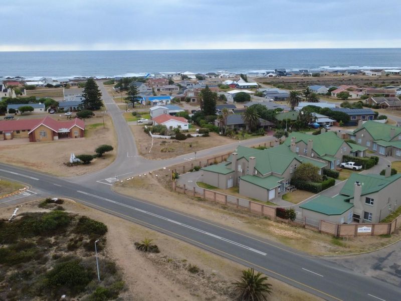 Aerial view of the coastal townhouse complex, showcasing the property's location, surrounding neighbourhood, and proximity to the ocean.
