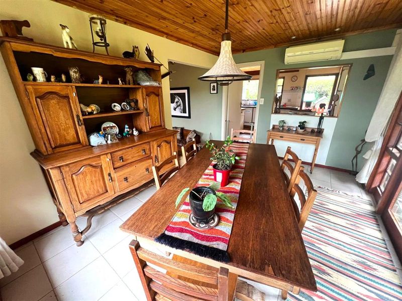Dining room featuring a timber ceiling, tiled flooring, and a convenient pass-through window connecting to the kitchen area.