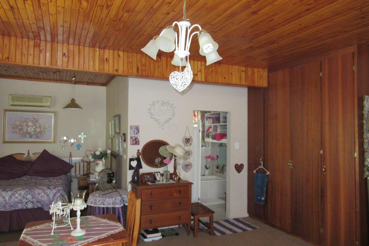 Spacious bedroom featuring warm wood-paneled ceilings, built-in wooden cabinetry, and an en-suite bathroom access.