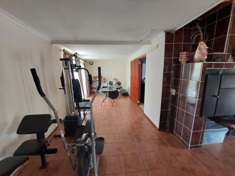 Spacious living area featuring tiled flooring and a prominent built-in fireplace with dark ceramic tiling.