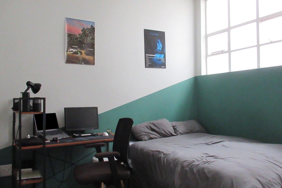 A bedroom featuring a large multi-pane window and a two-tone painted wall finish.