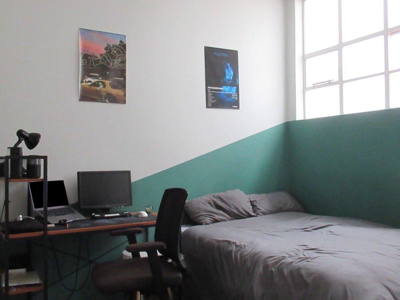 A bedroom featuring a large multi-pane window and a two-tone painted wall finish.