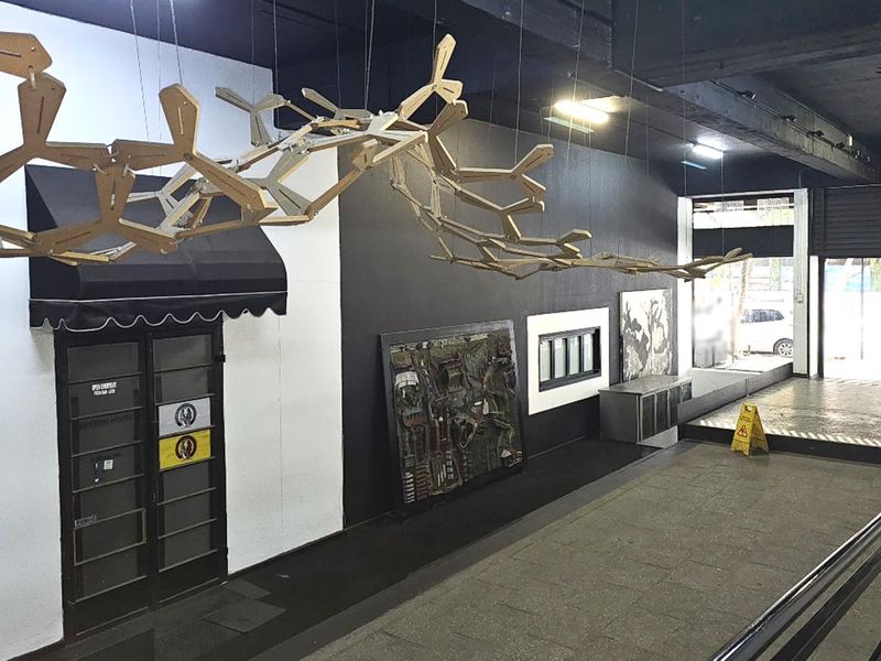 An open-plan commercial or industrial style space featuring exposed ceilings, tiled flooring, and a metal railing, suitable for various creative or retail uses.