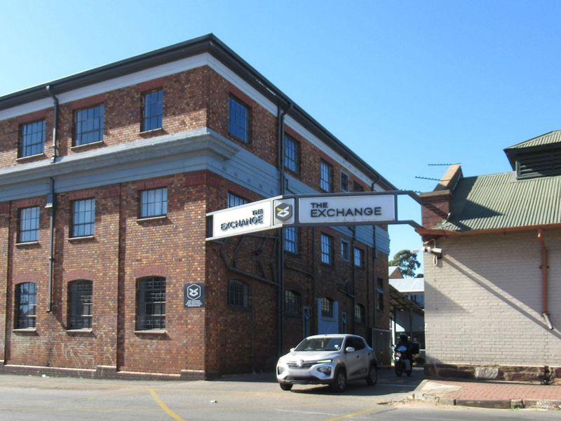 Exterior view of The Exchange building featuring industrial brick architecture and prominent signage.