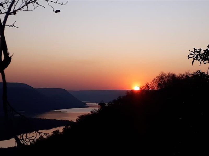 A scenic sunset view overlooking a river and mountainous landscape from the property.