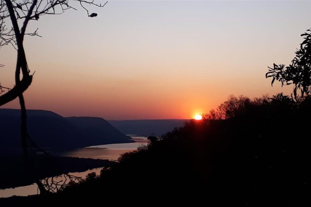 A scenic sunset view overlooking a river and mountainous landscape from the property.