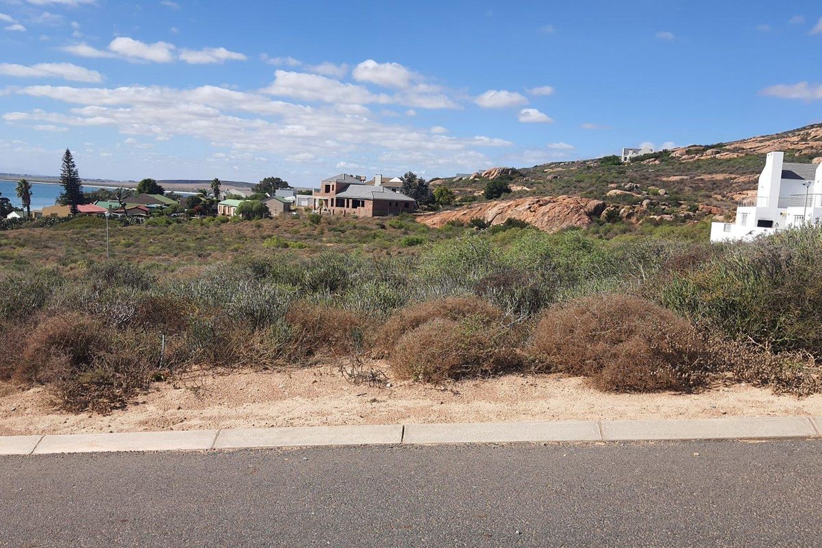 A vacant residential plot featuring natural coastal vegetation, offering scenic views of the surrounding landscape and nearby coastline.