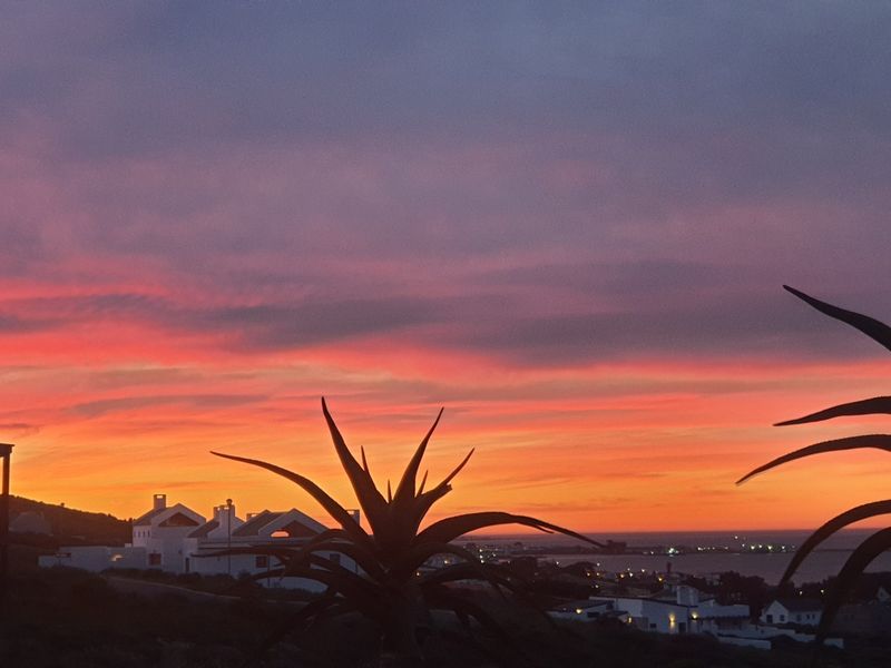 A scenic sunset view overlooking the coastal landscape and surrounding residential area.