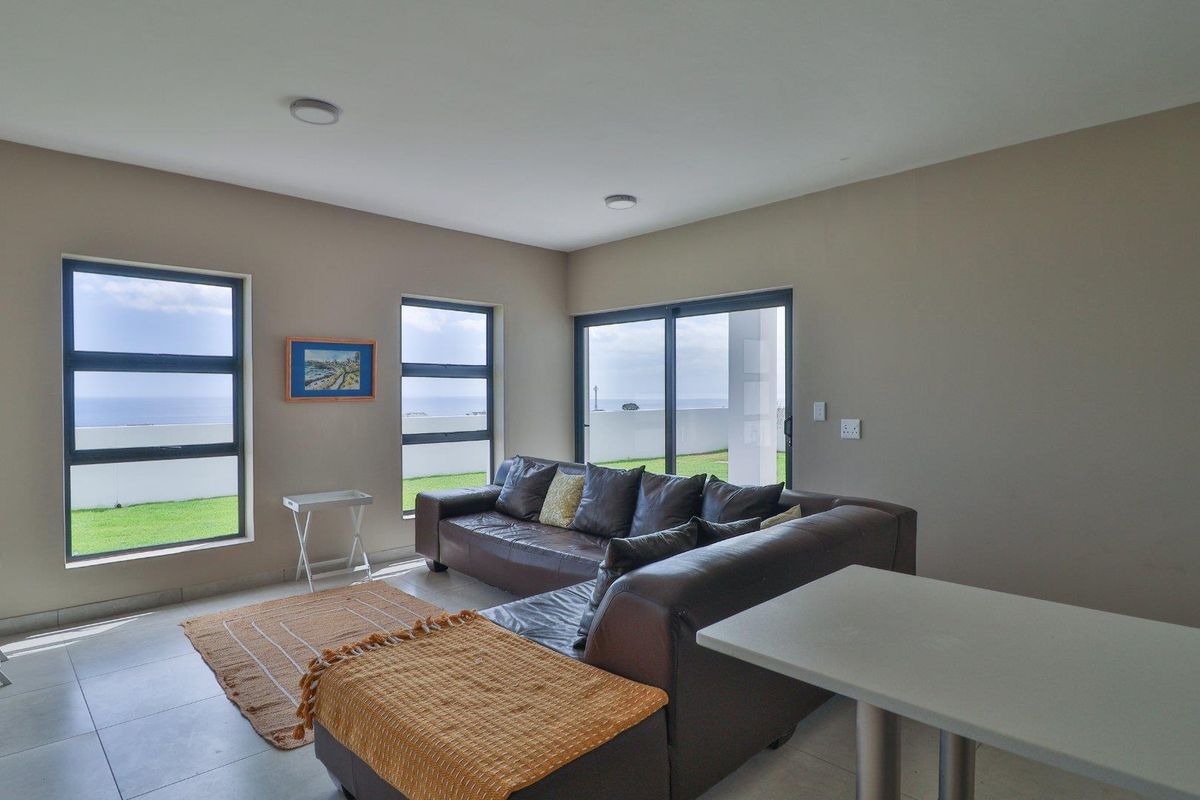 A bright living area featuring large windows and sliding glass doors that provide natural light and views of the outdoor space.