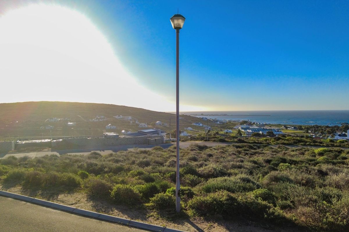 A scenic elevated view overlooking the coastal landscape and surrounding residential area, featuring natural vegetation and a clear horizon.