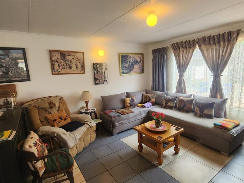 A comfortable living room featuring tiled flooring and large windows that allow for natural light.