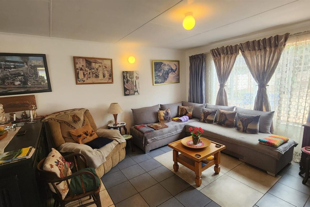A comfortable living room featuring tiled flooring and large windows that allow for natural light.