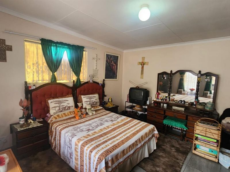 A bedroom featuring standard finishes, including a window with curtain tracks and a ceiling-mounted light fixture.