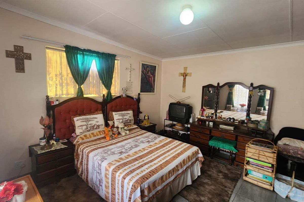 A bedroom featuring standard finishes, including a window with curtain tracks and a ceiling-mounted light fixture.