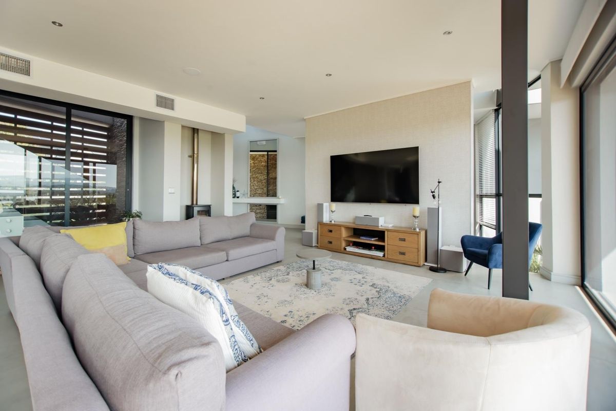 Spacious open-plan living area featuring a modern fireplace, large sliding glass doors, and recessed ceiling lighting, creating a bright and airy atmosphere.