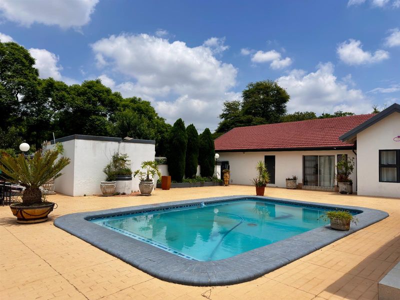 Outdoor pool area featuring a paved patio, swimming pool, and access to the main residence via sliding glass doors.