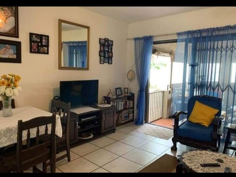 Living room area featuring tiled flooring and sliding glass doors providing access to an outdoor balcony space.
