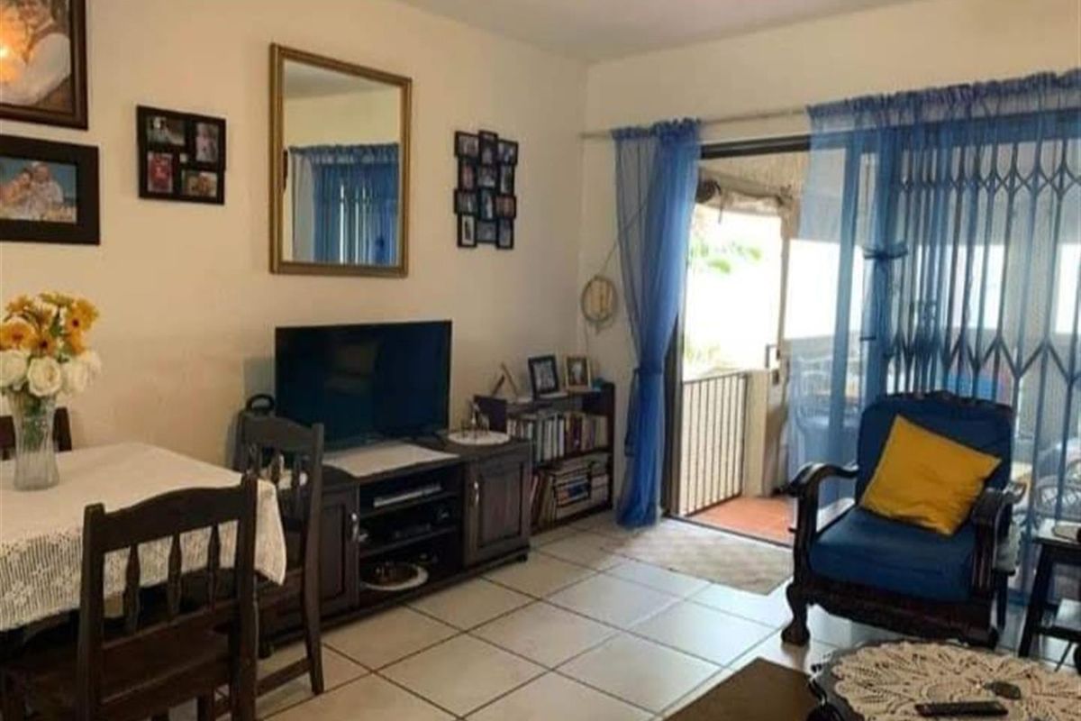 Living room area featuring tiled flooring and sliding glass doors providing access to an outdoor balcony space.