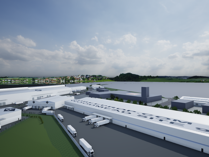 An aerial view of a large industrial warehouse complex featuring extensive loading docks, paved yard space, and clear site access.